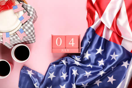 Calendar with date of Independence Day, American flag and picnic basket on color backgroundの写真素材