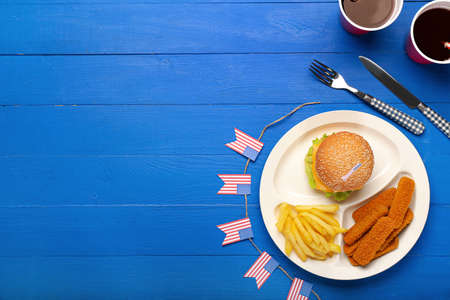 Plate with traditional American food on color wooden background