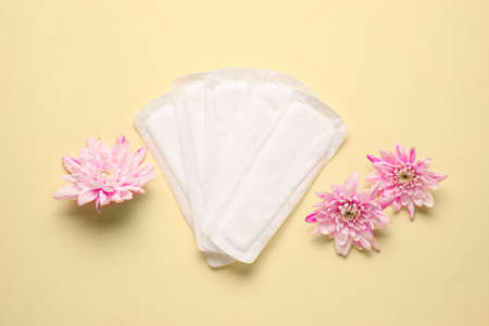 Menstrual pads and flowers on color backgroundの写真素材
