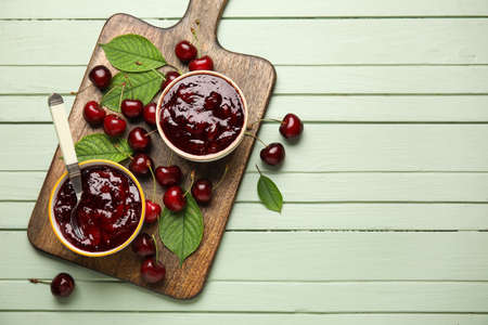 Bowls of tasty cherry jam on wooden backgroundの写真素材