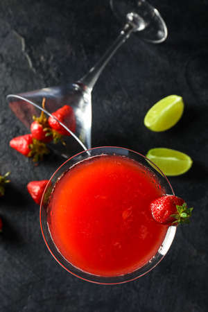 Glass of strawberry daiquiri cocktail, lime and berries on dark backgroundの写真素材
