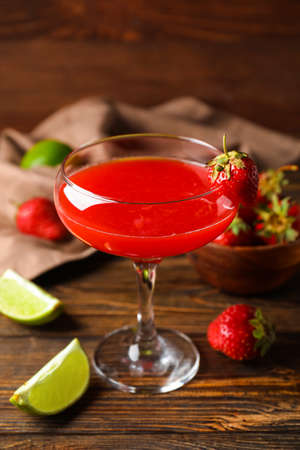 Glass of strawberry daiquiri cocktail, lime and berries on wooden backgroundの写真素材