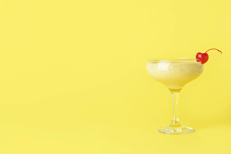 Glass of tasty banana daiquiri cocktail on color backgroundの写真素材