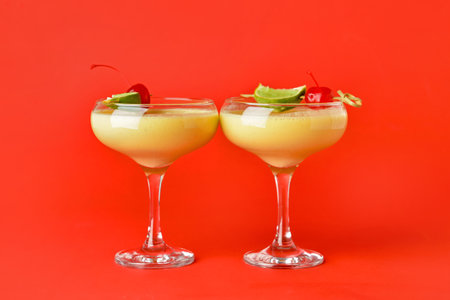 Glasses of tasty banana daiquiri cocktail on color background