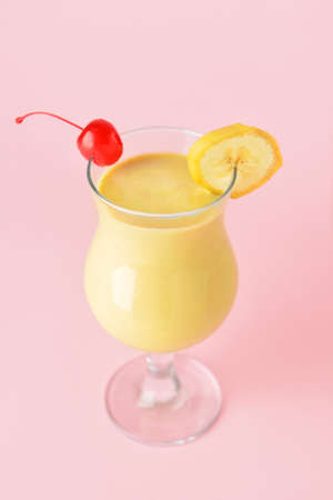 Glass of tasty banana daiquiri cocktail on color background