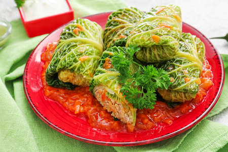 Plate with stuffed cabbage leaves and tomato sauce on tableの写真素材