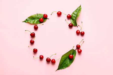 Frame made of tasty ripe cherry on color background