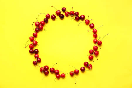 Frame made of tasty ripe cherry on color backgroundの写真素材