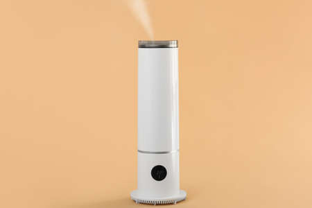 Modern humidifier on color background
