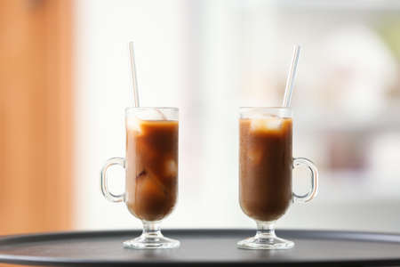 Glasses of tasty ice coffee on table