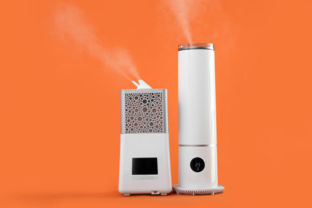 Modern humidifiers on color backgroundの写真素材