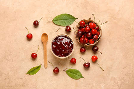 Composition with sweet cherry jam on color background