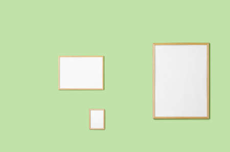 Blank frames hanging on green wallの写真素材