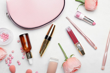 Composition with decorative cosmetics, bag and rose flowers on light backgroundの写真素材