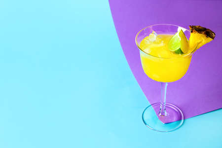 Glass of pineapple daiquiri cocktail on color backgroundの写真素材