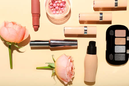 Composition with decorative cosmetics and beautiful rose flowers on color backgroundの写真素材