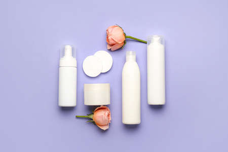 Composition with cosmetic products, cotton pads and rose flowers on lilac backgroundの写真素材