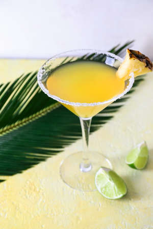 Glass of pineapple daiquiri cocktail on light background