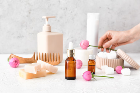 Set of bath supplies and rose flowers on light backgroundの写真素材