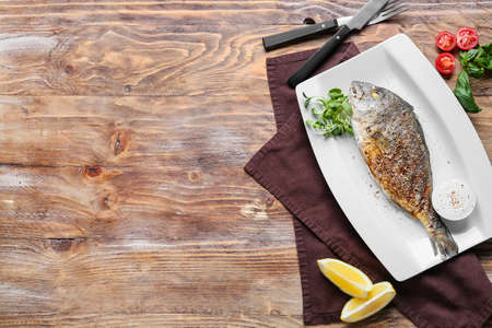 Plate with fried dorado on wooden backgroundの写真素材