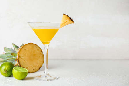 Glass of pineapple daiquiri cocktail on light background