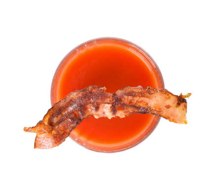 Glass of bloody mary cocktail garnished with bacon on white backgroundの写真素材