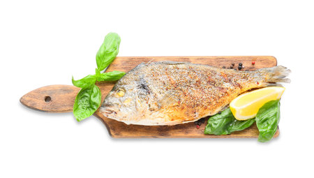 Wooden board with fried dorado on white background