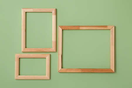 Wooden frames hanging on color wallの写真素材