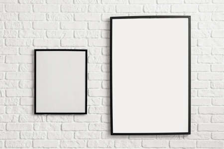 Blank poster frames hanging on brick wallの写真素材