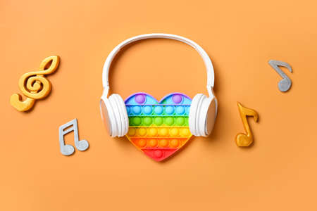 Pop it fidget toy, headphones and music notes on color backgroundの写真素材
