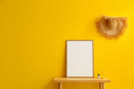 Wooden table with frame near color wallの写真素材