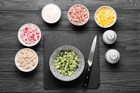 Bowls with different ingredients for okroshka on dark wooden backgroundの写真素材