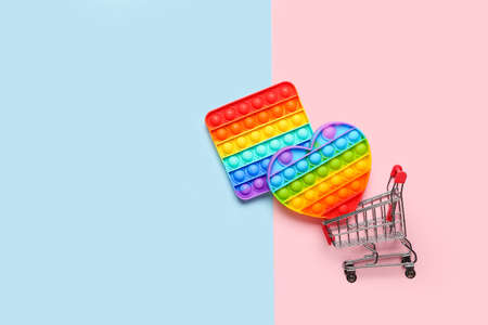 Pop it fidget toys and shopping cart on color backgroundの写真素材
