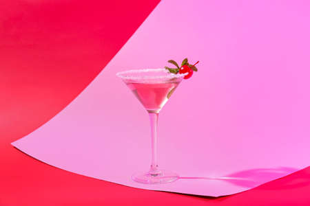 Glass of tasty cosmopolitan cocktail on color backgroundの写真素材