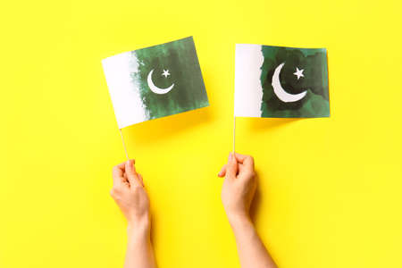 Female hands with Pakistan flags on color backgroundの写真素材