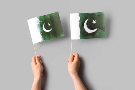 Female hands with Pakistan flag on light backgroundの写真素材