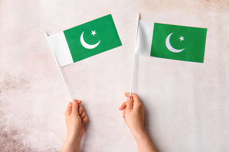 Female hands with Pakistan flags on grunge backgroundの写真素材