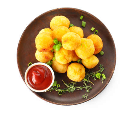 Plate with fried potato balls on white background