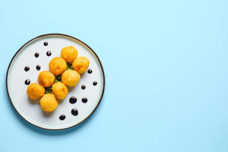 Plate with fried potato balls on color backgroundの写真素材
