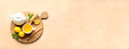 Composition with hot tea, ginger and lemons on color background with space for textの写真素材