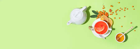 Composition with tasty rowan tea, honey and cookies on green background background with space for textの写真素材