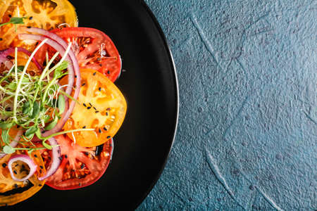 Plate with tasty tomato carpaccio on dark background, closeupの写真素材