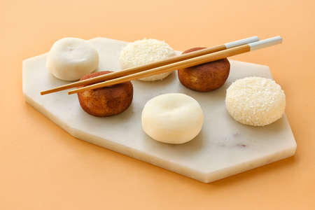 Board with tasty Japanese mochi on color backgroundの写真素材