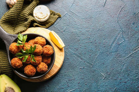 Frying pan with tasty cod cutlets and sauce on dark backgroundの写真素材