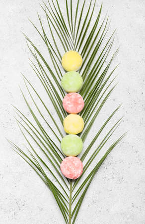 Delicious mochi and palm leaf on grunge background