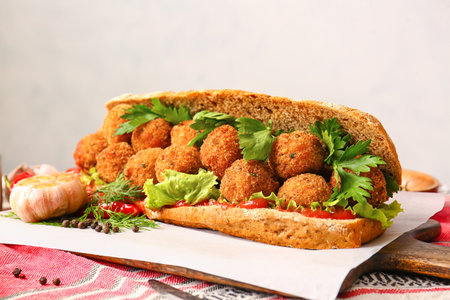 Board with bread and tasty cod cutlets on table