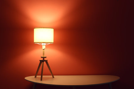 Glowing lamp on table in dark room