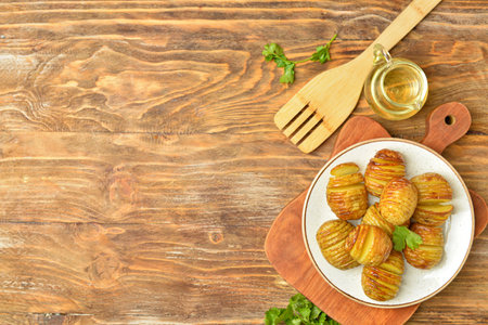 Plate with tasty baked potato on wooden background
