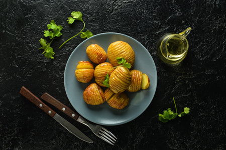 Plate with tasty baked potato on dark backgroundの写真素材