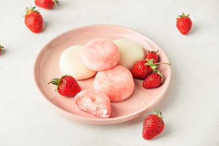 Plate with tasty Japanese mochi and strawberry on light backgroundの写真素材